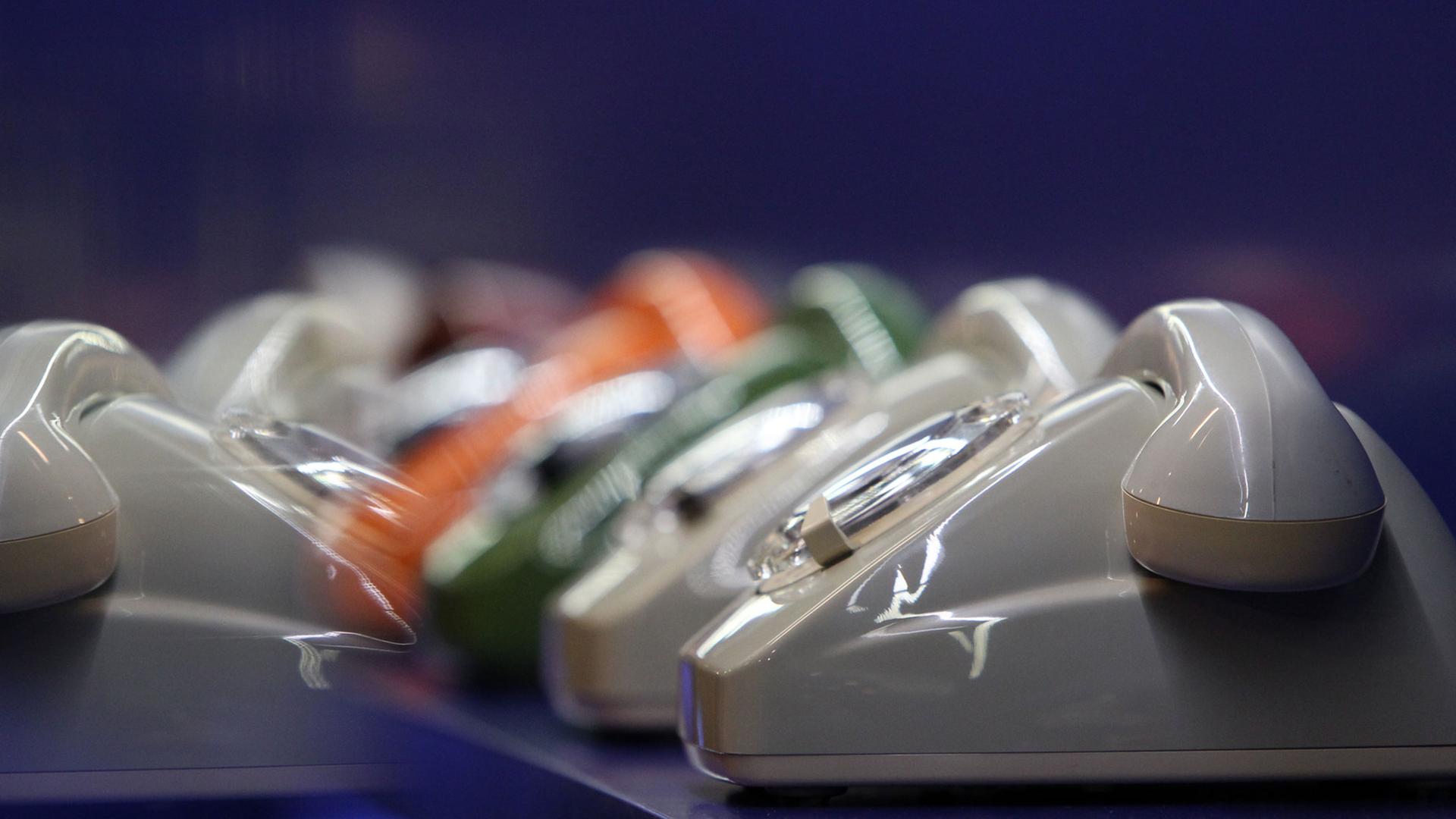Telefone mit Wahlscheibe spiegeln sich im Museum für Kommunikation in Nürnberg (Mittelfranken) in einer Vitrine.