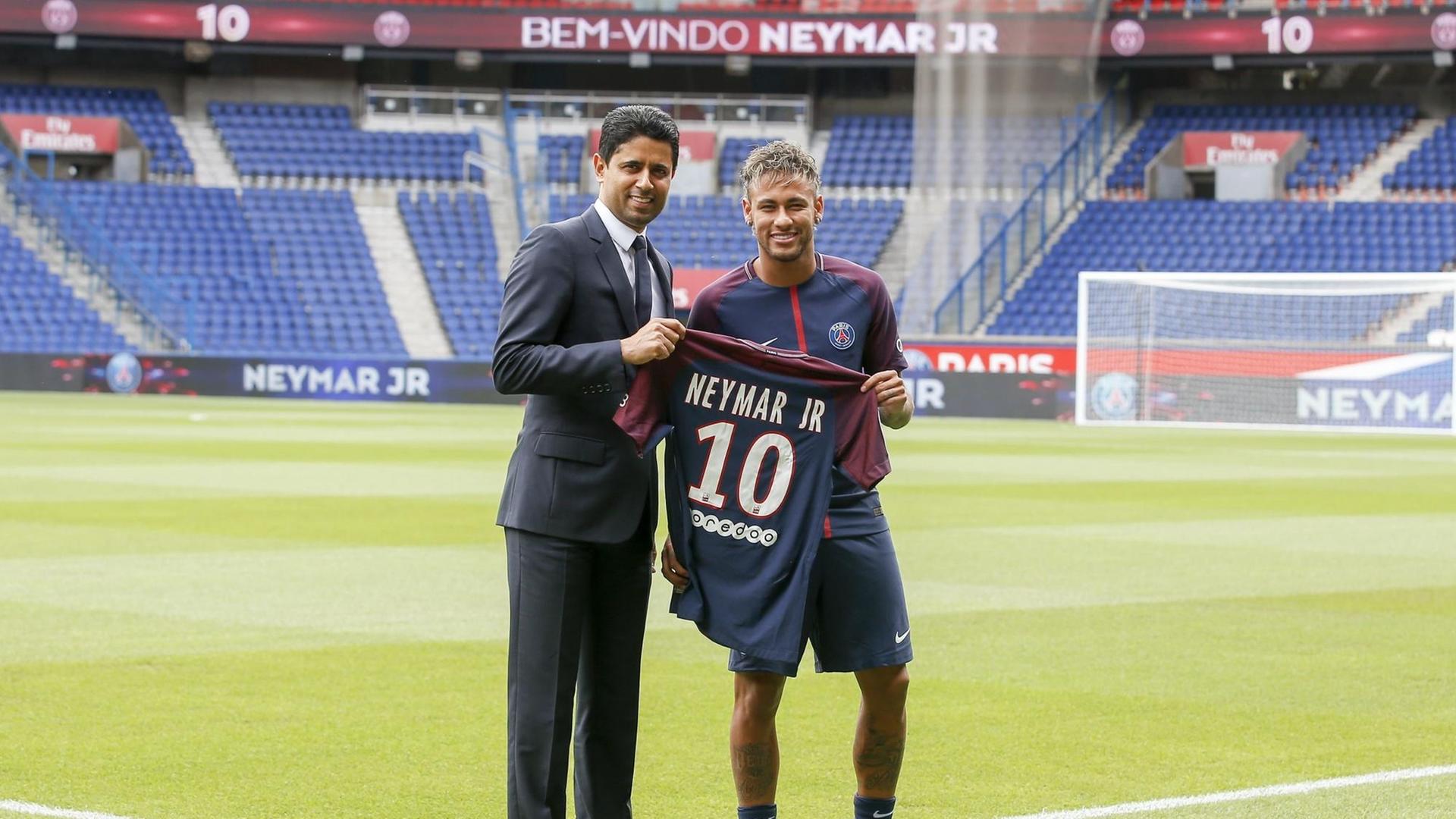 PSG-Präsident Nasser al-Khelaifi und Fußballer Neymar halten im Stadion dessen Trikot hoch. PSG-Präsident Nasser al-Khelaifi und Fußballer Neymar halten im Stadion dessen Trikot hoch.