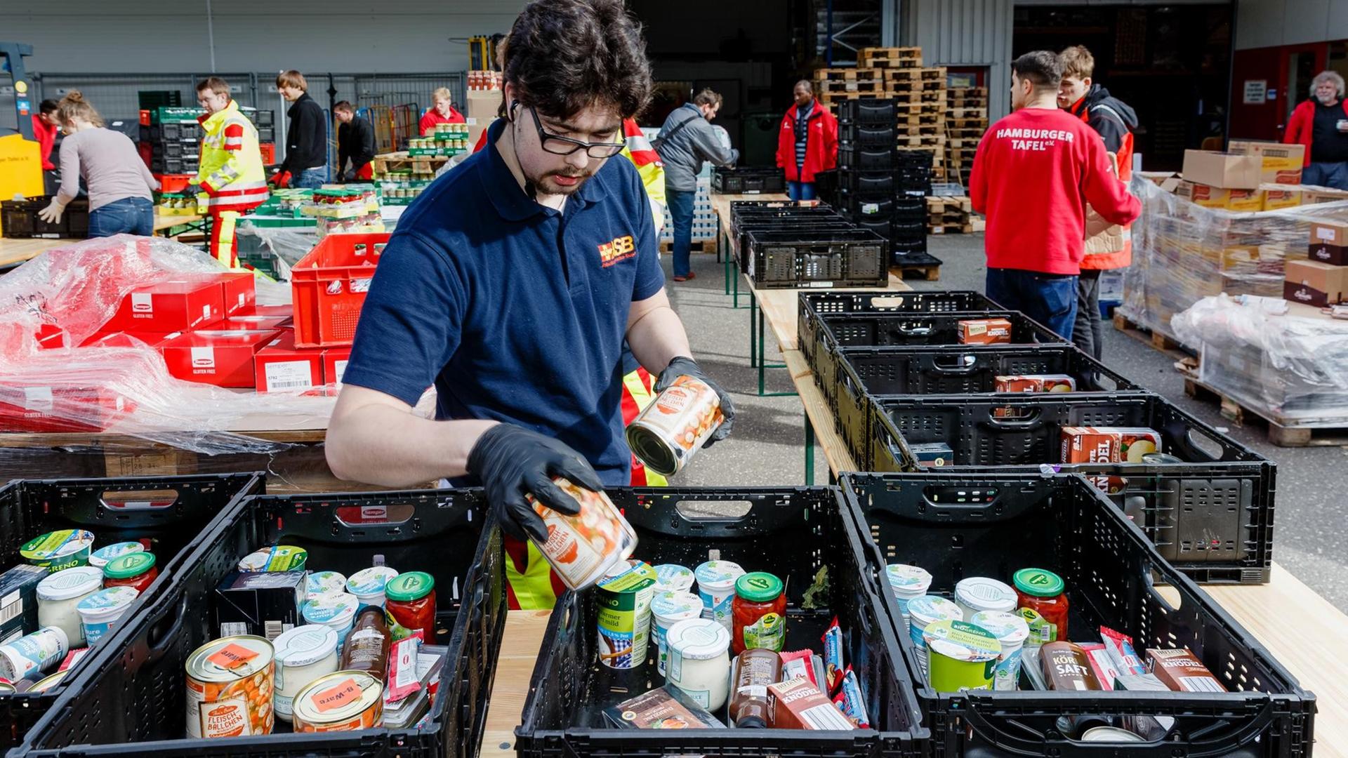 Ehrenamtliche Helfer des Hamburger Tafel und des Arbeiter-Samariter-Bunds packen im Zentraldepot Kisten mit Lebensmitteln für die Ausgabestellen der Tafeln. Ehrenamtliche Helfer des Hamburger Tafel und des Arbeiter-Samariter-Bunds packen im Zentraldepot Kisten mit Lebensmitteln für die Ausgabestellen der Tafeln.