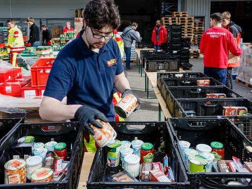 Ehrenamtliche Helfer des Hamburger Tafel und des Arbeiter-Samariter-Bunds packen im Zentraldepot Kisten mit Lebensmitteln für die Ausgabestellen der Tafeln.