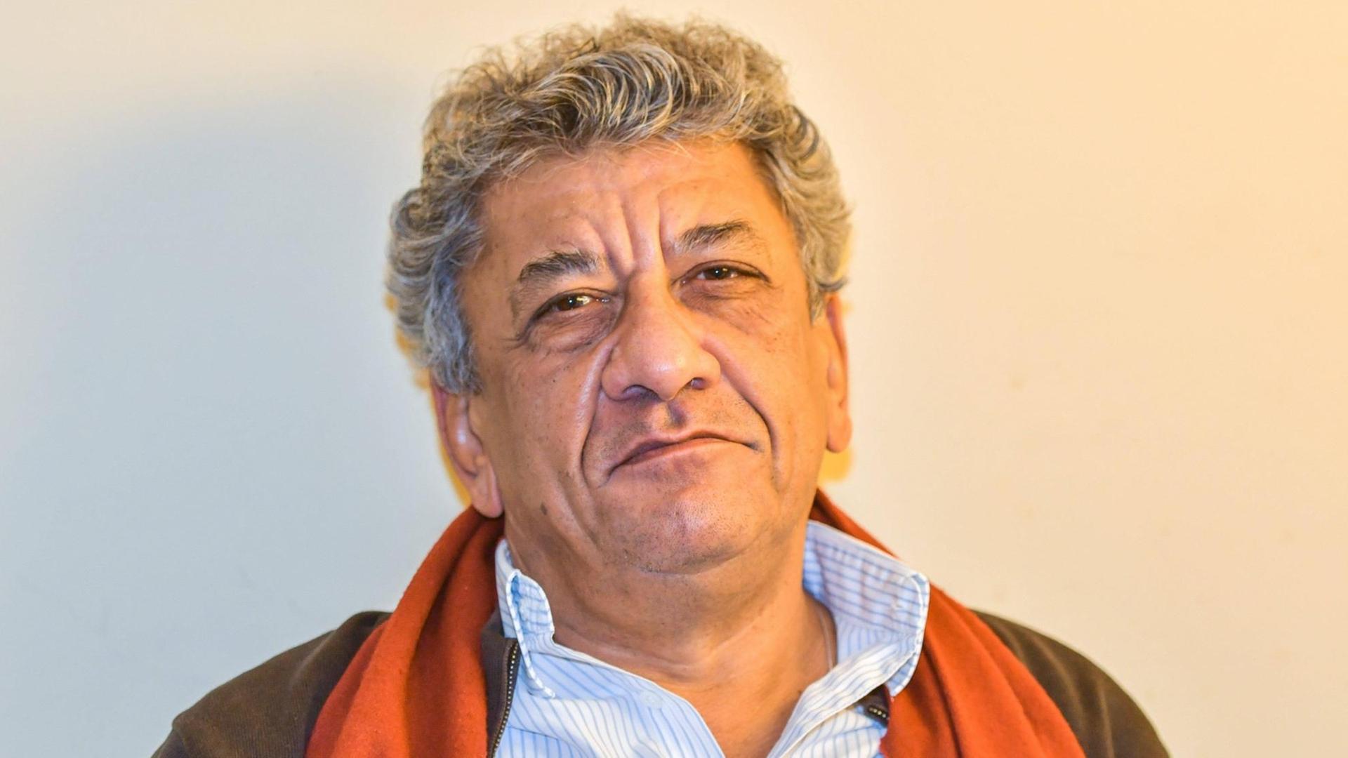 Najem Wali hat weißes Har. Er trägt sein helles Hemd offen, über der Jacke hat er ein rotes Tuch gelegt. Najem Wali hat weißes Har. Er trägt sein helles Hemd offen, über der Jacke hat er ein rotes Tuch gelegt.