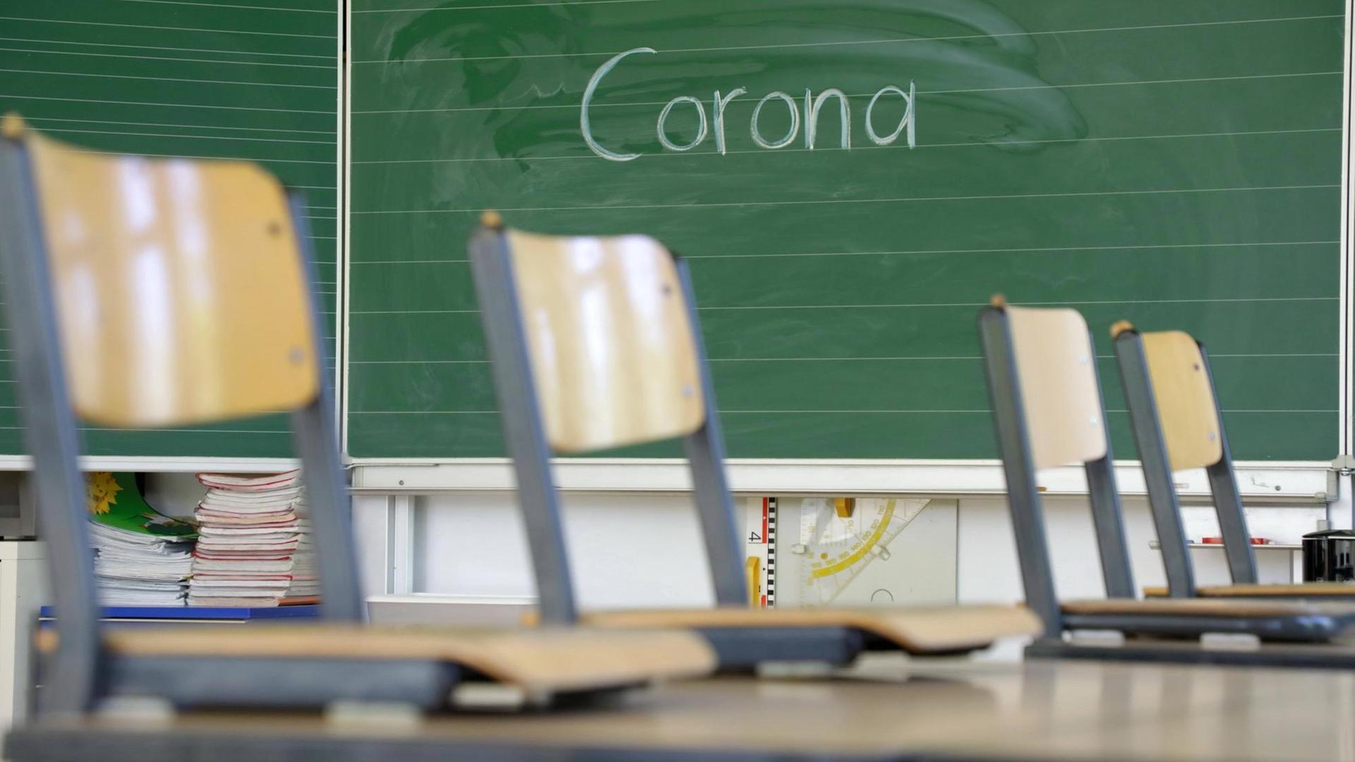 Stühle auf dem Tisch in einem leeren Klassenzimmer Stühle auf dem Tisch in einem leeren Klassenzimmer