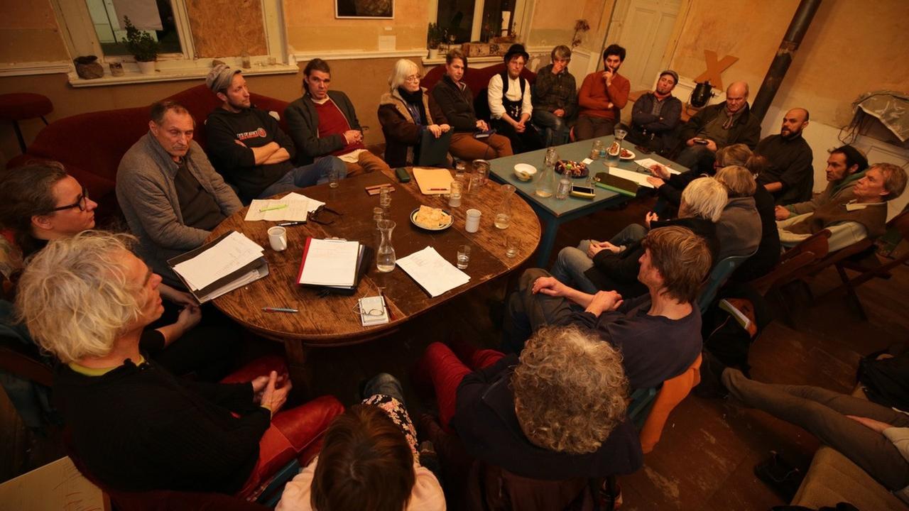 Menschen sitzen um einen Tisch Menschen sitzen um einen Tisch