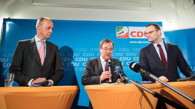 Friedrich Merz (l-r), Armin Laschet, Ministerpräsident von Nordrhein-Westfalen und Jens Spahn, Bundes-Gesundheitsminister sitzen bei einer Pressekonferenz gemeinsam auf dem Podium.