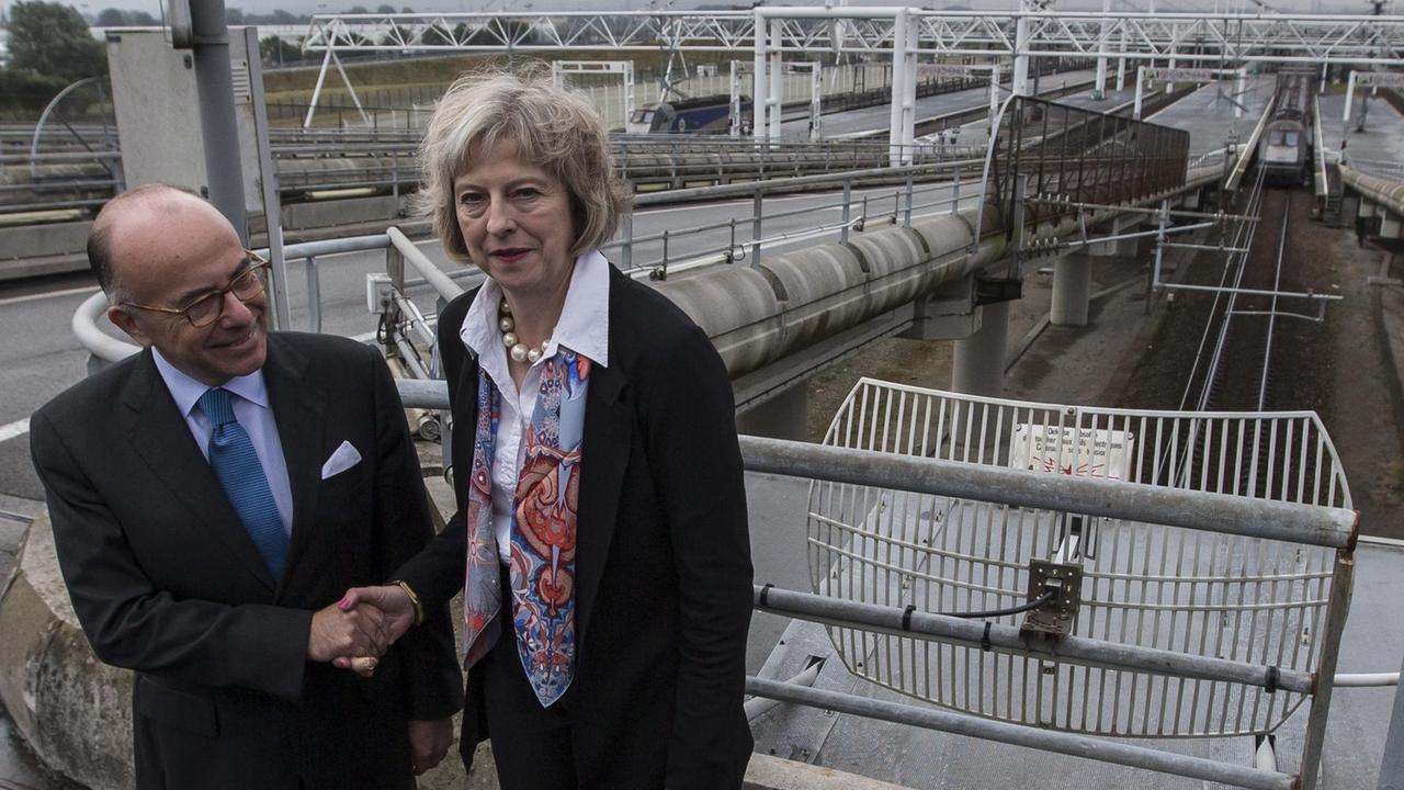 Französisch Innenminister Bernard Cazeneuve und britischen Amtskollegen Theresa May Hände schüttelnd. Beide haben eine Vereinbarung zur Flüchtlingssicherung des Eurotunnels in Calais unterzeichnet. Französisch Innenminister Bernard Cazeneuve und britischen Amtskollegen Theresa May Hände schüttelnd. Beide haben eine Vereinbarung zur Flüchtlingssicherung des Eurotunnels in Calais unterzeichnet.