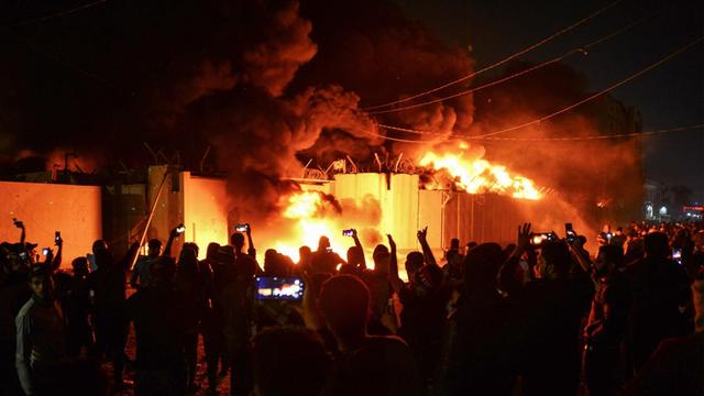 Demonstranten stehen vor dem brennenden Gebäude des iranischen Konsulat im Süden des Irak.