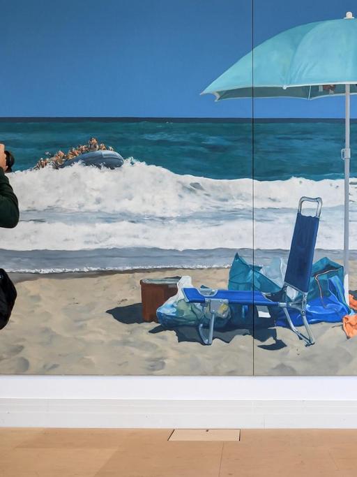 Ein junger Mann fotografiert das Gemälde "Beach of Plenty" des Künstlers Michael Kvium in der Ausstellung "Durch Mauern gehen" zum 30. Jahrestag des Falls der Berliner Mauer im Martin-Gropius-Bau. Die Ausstellung läuft vom 12.09.2019 bis 19.01.2020