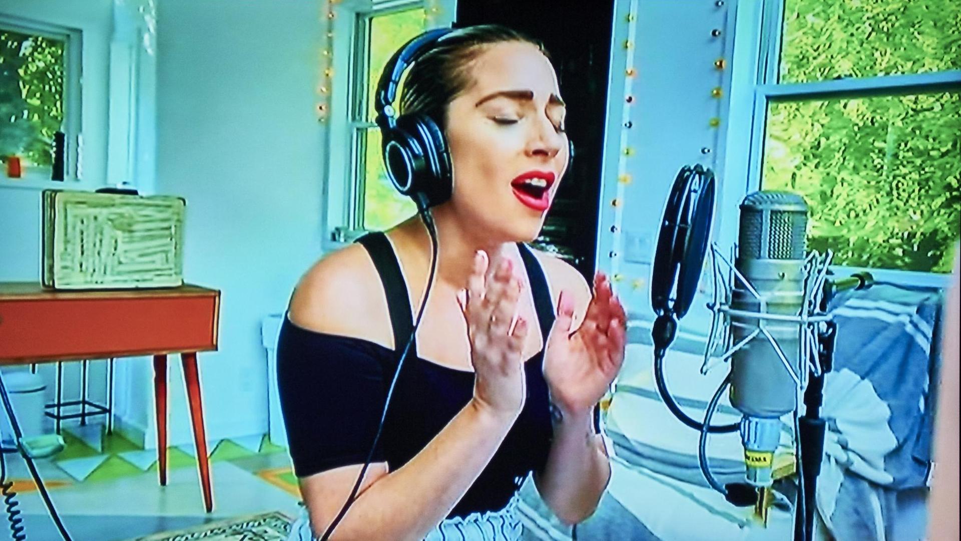Die Sängerin Lady Gaga singt im Wohn-Zimmer. Die Sängerin Lady Gaga singt im Wohn-Zimmer.