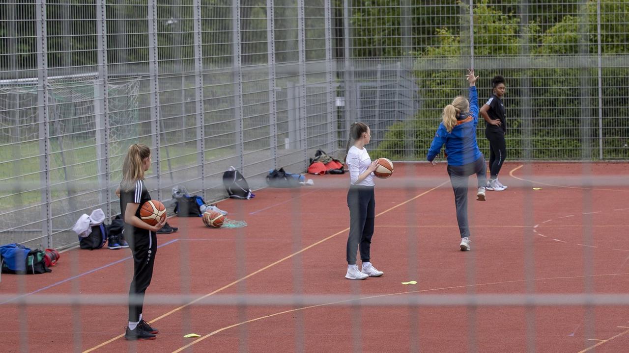 Schülerinnen in Würzburg auf einem Basketballplatz im Freien. Schülerinnen in Würzburg auf einem Basketballplatz im Freien.