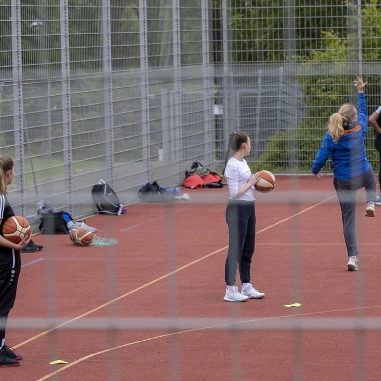 Schülerinnen in Würzburg auf einem Basketballplatz im Freien.