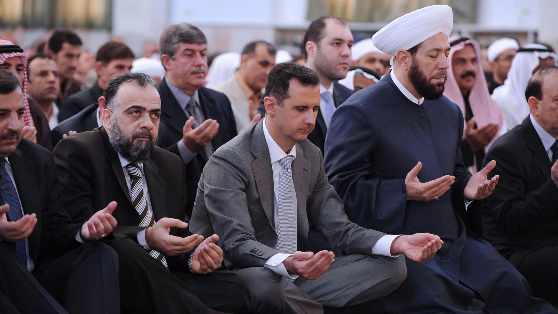 Ein offizielles Foto, herausgebracht von der 'Syrian Arab News Agency' (SANA), zeigt den syrischen Präsidenten Bashar al-Assad betend in der al-Nour Moschee in der Provinz Raqqa im Nordosten Syriens am ersten Tag des islamischen Opferfestes am 06. November 2011. Ein offizielles Foto, herausgebracht von der 'Syrian Arab News Agency' (SANA), zeigt den syrischen Präsidenten Bashar al-Assad betend in der al-Nour Moschee in der Provinz Raqqa im Nordosten Syriens am ersten Tag des islamischen Opferfestes am 06. November 2011.
