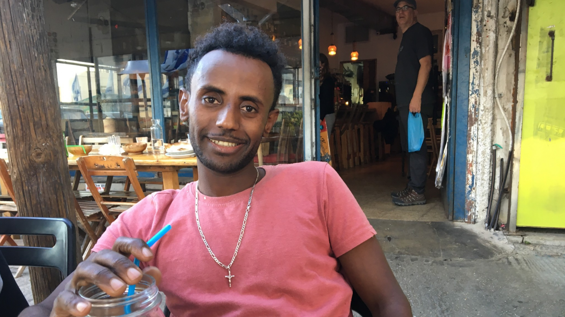Der Eritreer Haben sitzt vor einem Restaurant in Tel Aviv Der Eritreer Haben sitzt vor einem Restaurant in Tel Aviv