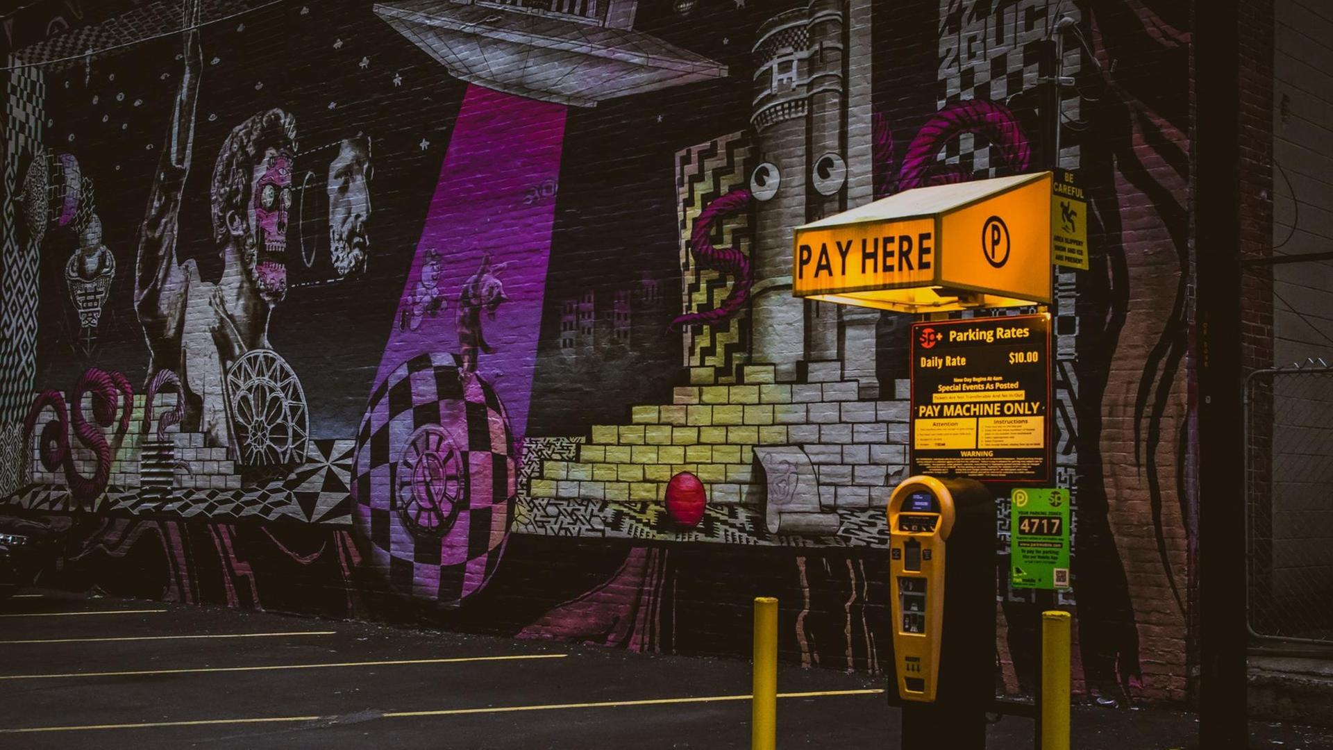 Ein Parkautomat vor einer Wand voller Graffitis. Ein Parkautomat vor einer Wand voller Graffitis.