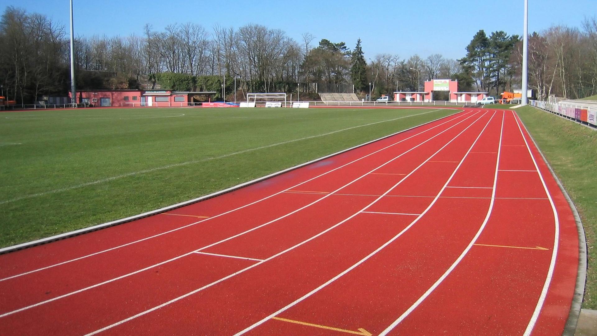 Eine leere rote Laufbahn auf einem Sportfeld Eine leere rote Laufbahn auf einem Sportfeld