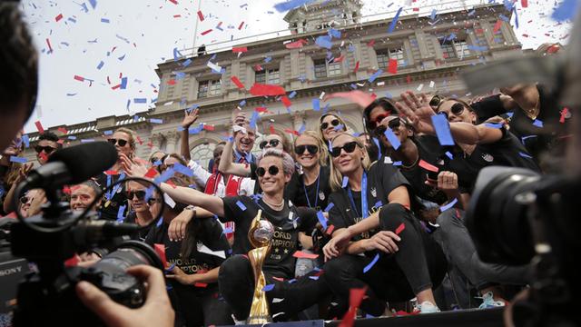 USA, New York: Die Fußballerinnen der Frauenfußballmannschaft aus den USA mit Megan Rapinoe (M) feiern am Rathaus während einer Konfetti-Parade ihren WM-Erfolg. Die US-Nationalmannschaft besiegte die Niederlande mit 2:0 und holte damit den vierten Weltmeistertitel der Frauen.