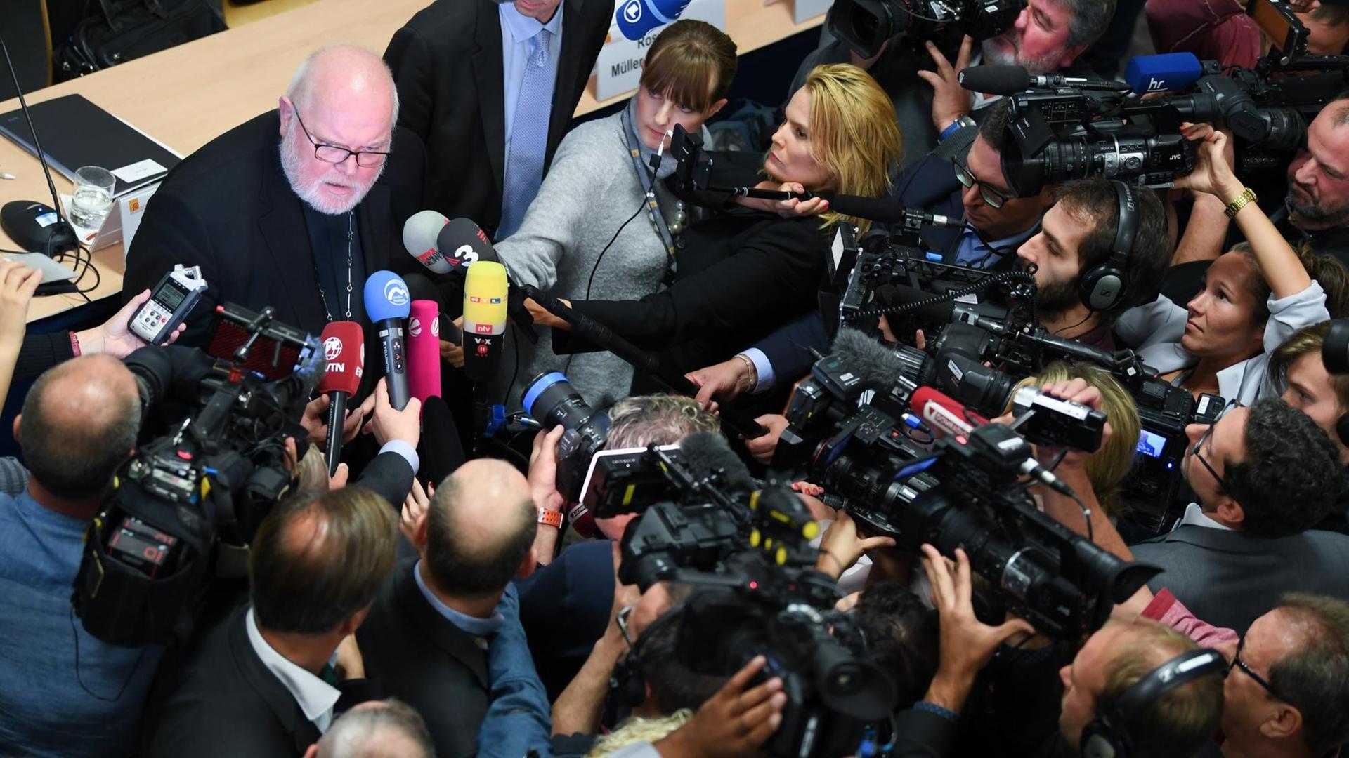 Hessen, Fulda: Kardinal Reinhard Marx, links, Erzbischof von München und Freising und Vorsitzender der Deutschen Bischofskonferenz, ist im Anschluss einer Pressekonferenz der Deutschen Bischofskonferenz zur Vorstellung der Studie "Sexueller Missbrauch an Minderjährigen durch katholische Priester, Diakone und männliche Ordensangehörige im Bereich der Deutschen Bischofskonferenz" von Kameras umringt. Hessen, Fulda: Kardinal Reinhard Marx, links, Erzbischof von München und Freising und Vorsitzender der Deutschen Bischofskonferenz, ist im Anschluss einer Pressekonferenz der Deutschen Bischofskonferenz zur Vorstellung der Studie "Sexueller Missbrauch an Minderjährigen durch katholische Priester, Diakone und männliche Ordensangehörige im Bereich der Deutschen Bischofskonferenz" von Kameras umringt.