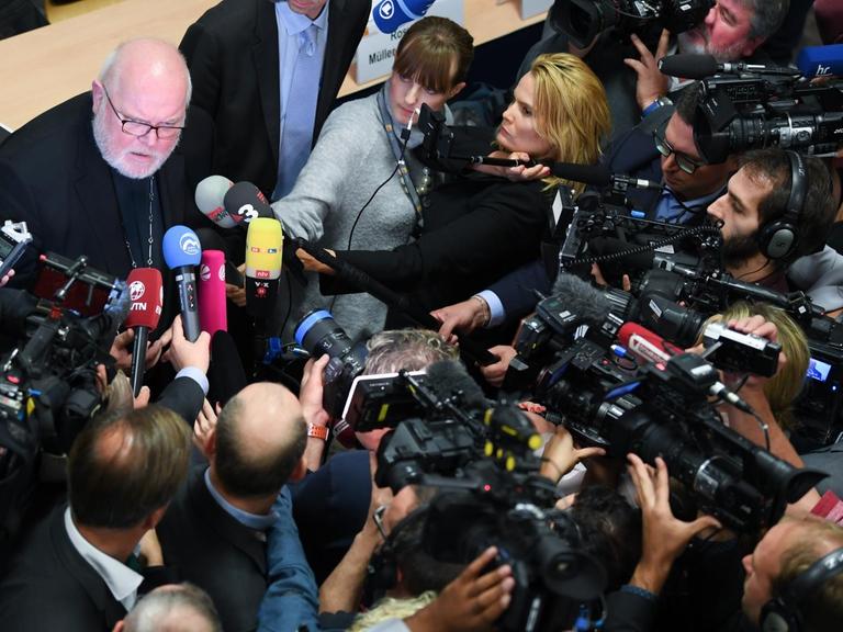 Hessen, Fulda: Kardinal Reinhard Marx, links, Erzbischof von München und Freising und Vorsitzender der Deutschen Bischofskonferenz, ist im Anschluss einer Pressekonferenz der Deutschen Bischofskonferenz zur Vorstellung der Studie "Sexueller Missbrauch an Minderjährigen durch katholische Priester, Diakone und männliche Ordensangehörige im Bereich der Deutschen Bischofskonferenz" von Kameras umringt.