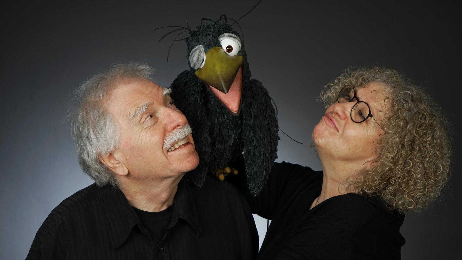Claudia Röders trägt auf der Hand die Puppe Rudi, einen Raben, und setzt ihn fröhlich auf die Schulter ihres Mannes Peter Röders. Claudia Röders trägt auf der Hand die Puppe Rudi, einen Raben, und setzt ihn fröhlich auf die Schulter ihres Mannes Peter Röders.