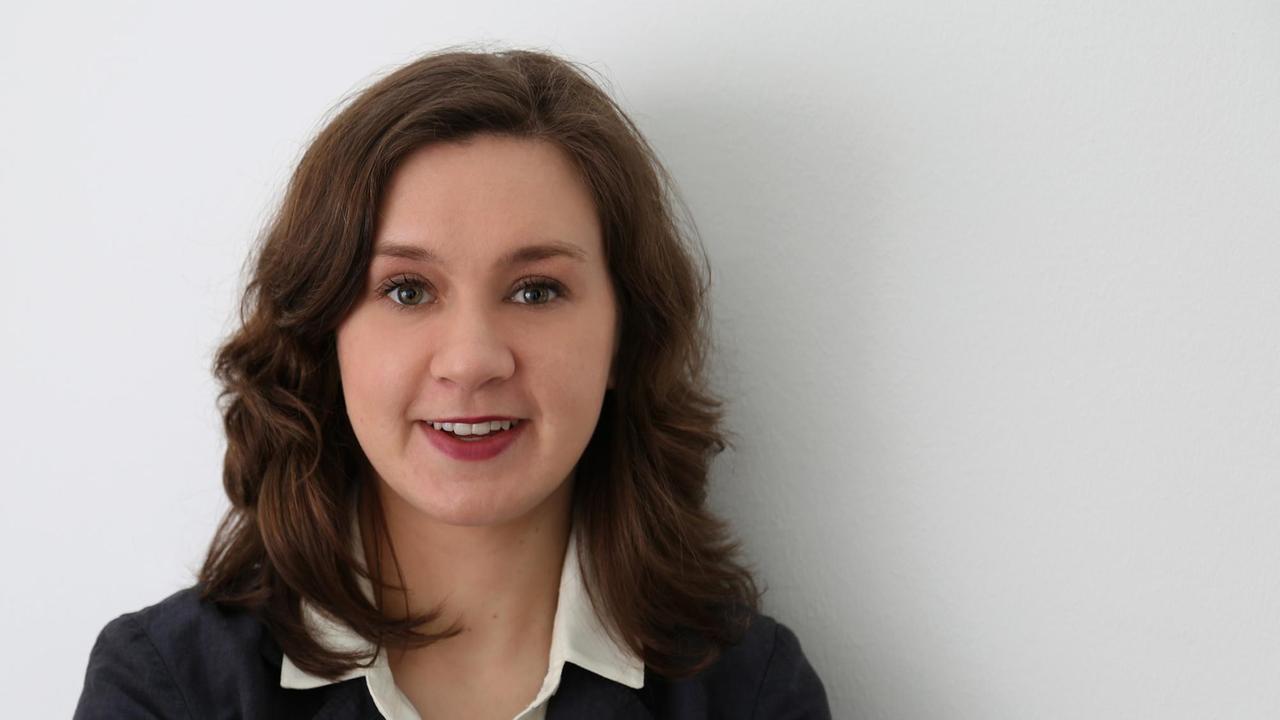 Katharina Gnath steht vo einer weißen Wand, trägt eine weiße Bluse und ein dunkles Sakko und schaut freundlich in die Kamera. Katharina Gnath steht vo einer weißen Wand, trägt eine weiße Bluse und ein dunkles Sakko und schaut freundlich in die Kamera.