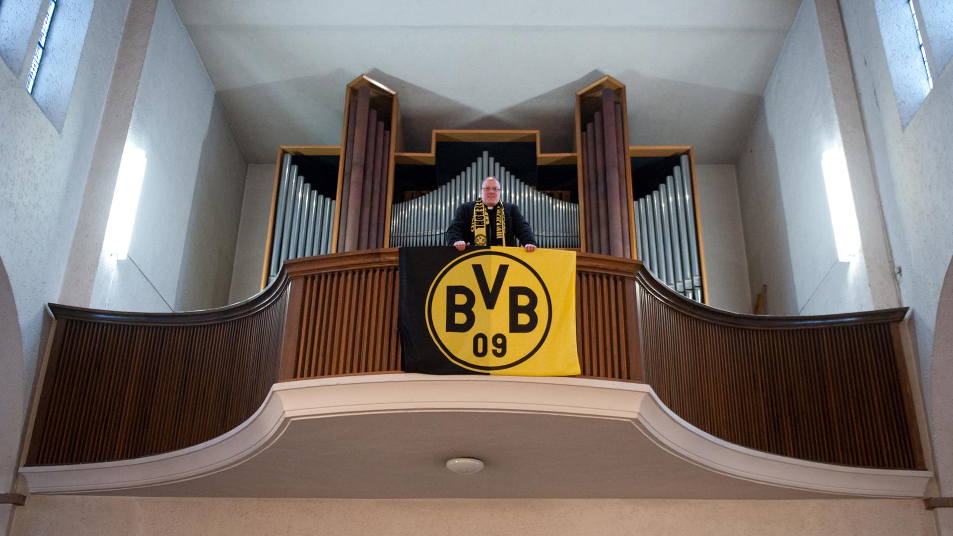 Pfarrer Ansbert Junk steht am Freitag (10.12.2010) in der Dreifaltigkeitskirche in Dortmund auf der Orgelempore, an der eine BVB-Fahne hängt. Dortmund ist ganz oben. Der Siegeskurs der Fußballer von Borussia verleiht der Ruhrgebietsstadt ein völlig neues Selbstvertrauen Pfarrer Ansbert Junk steht am Freitag (10.12.2010) in der Dreifaltigkeitskirche in Dortmund auf der Orgelempore, an der eine BVB-Fahne hängt. Dortmund ist ganz oben. Der Siegeskurs der Fußballer von Borussia verleiht der Ruhrgebietsstadt ein völlig neues Selbstvertrauen