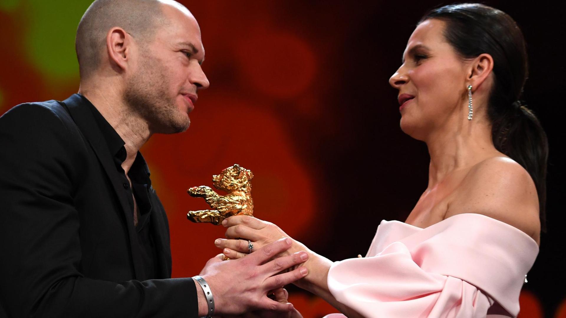 16.02.2019, Berlin: 69. Berlinale: Abschluss und Verleihung der Bären im Berlinale Palast: Juliette Binoche (r), Jury-Präsidentin, übergibt den Goldenen Bär an Nadav Lapid, Regisseur, und dessen Film «Synonymes (Synonyms)». 16.02.2019, Berlin: 69. Berlinale: Abschluss und Verleihung der Bären im Berlinale Palast: Juliette Binoche (r), Jury-Präsidentin, übergibt den Goldenen Bär an Nadav Lapid, Regisseur, und dessen Film «Synonymes (Synonyms)».
