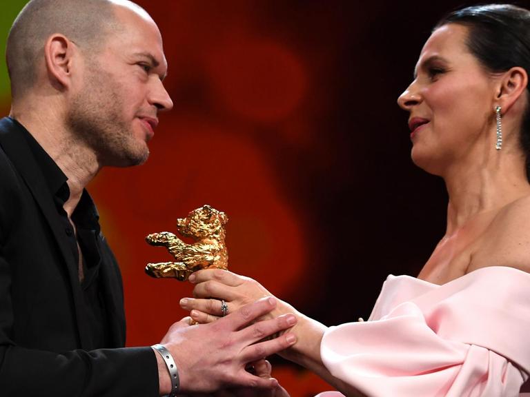 16.02.2019, Berlin: 69. Berlinale: Abschluss und Verleihung der Bären im Berlinale Palast: Juliette Binoche (r), Jury-Präsidentin, übergibt den Goldenen Bär an Nadav Lapid, Regisseur, und dessen Film «Synonymes (Synonyms)».