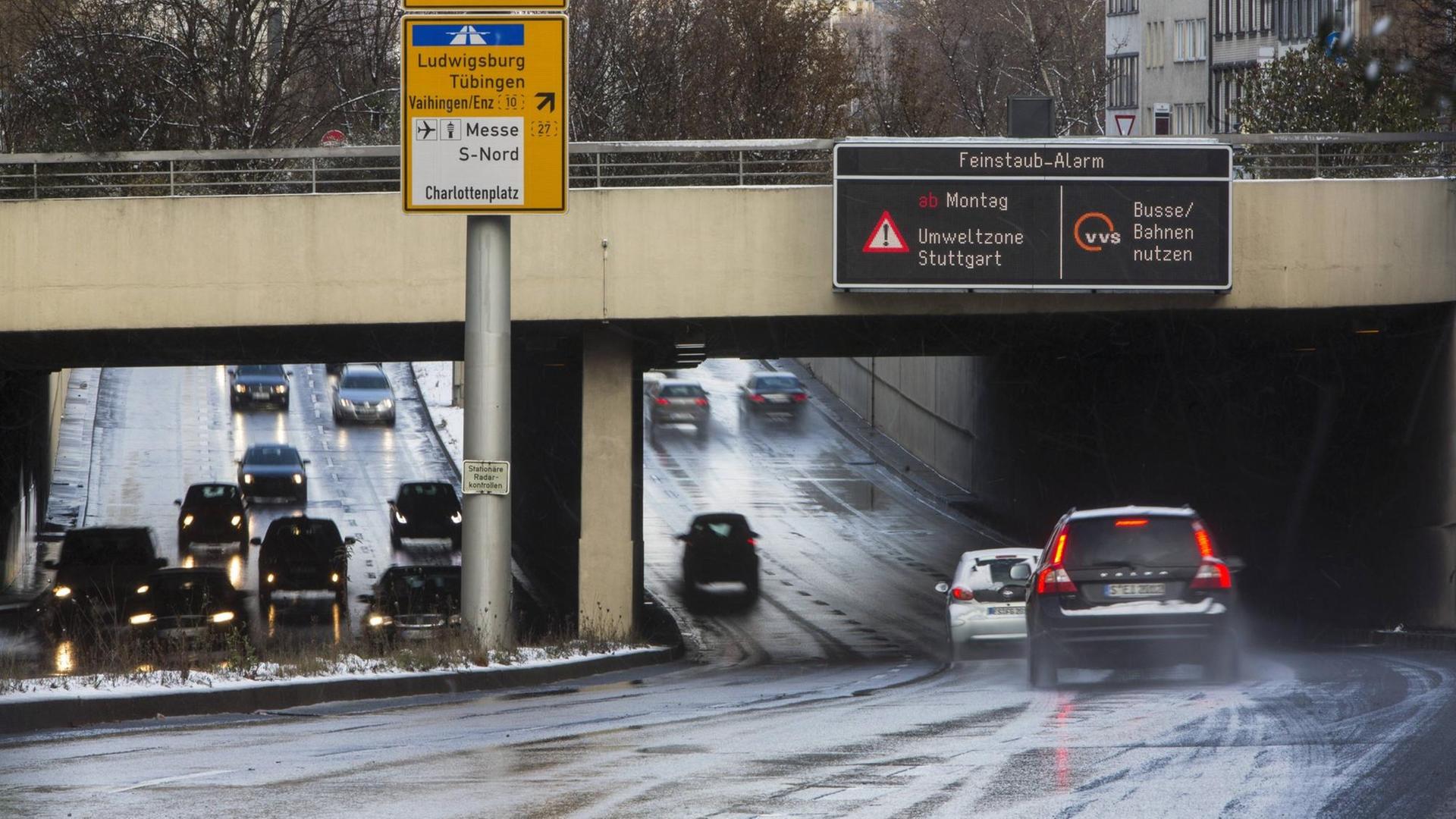 Autos fahren unter einer Brücke hindurch, an der ein Warnschild mit der Aufschrift "Feinstaub-Alarm Umweltzone Stuttgart - bitte Busse und Bahnen nutzen" hängt. Autos fahren unter einer Brücke hindurch, an der ein Warnschild mit der Aufschrift "Feinstaub-Alarm Umweltzone Stuttgart - bitte Busse und Bahnen nutzen" hängt.
