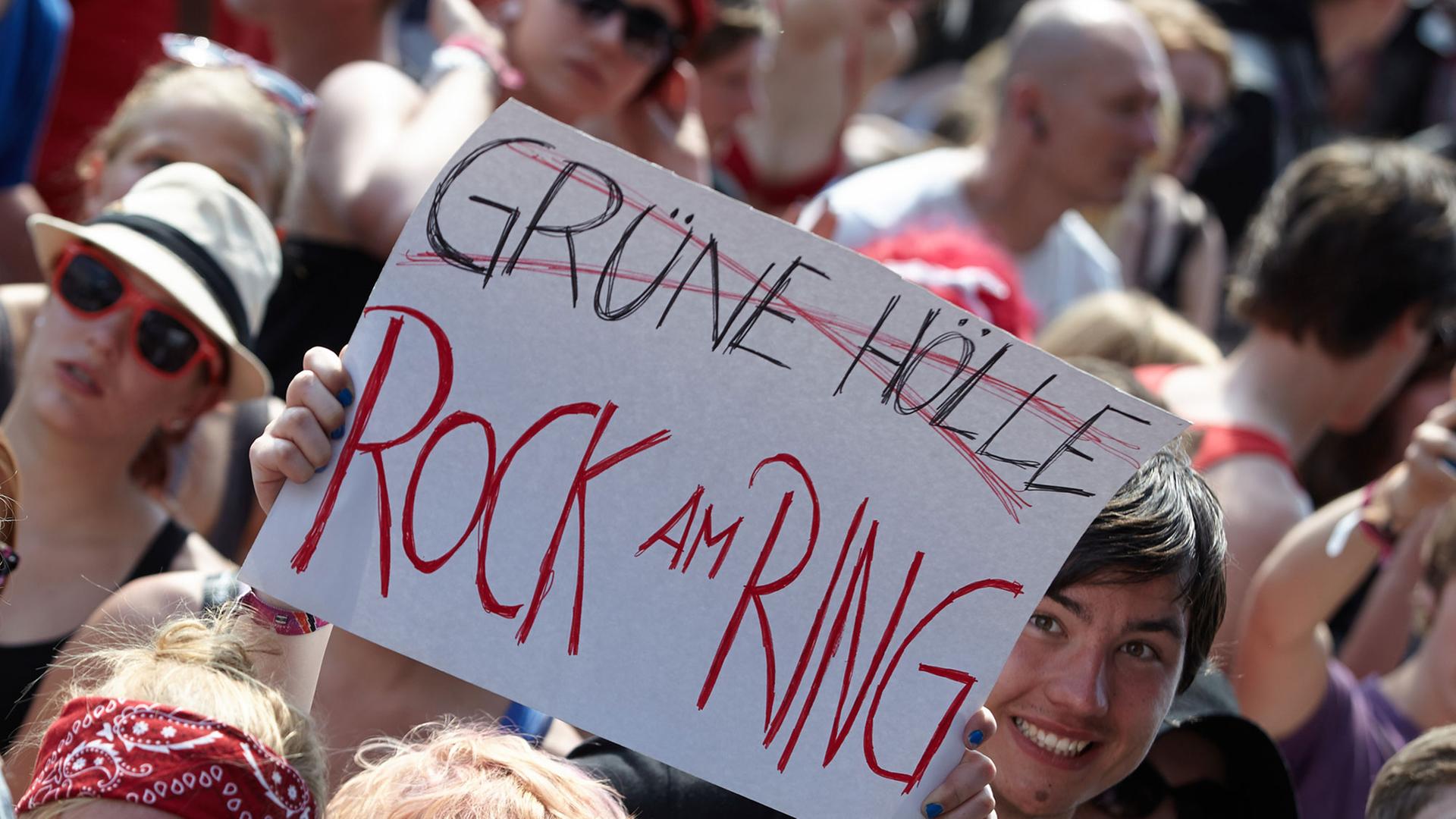 Zuschauer zeigen am 06.06.2014 beim Rockfestival "Rock am Ring" auf dem Nürburgring eine Tafel, mit der sie gegen die Nachfolgeveranstaltung "Grüne Hölle-Rockfestival" protestieren. Zuschauer zeigen am 06.06.2014 beim Rockfestival "Rock am Ring" auf dem Nürburgring eine Tafel, mit der sie gegen die Nachfolgeveranstaltung "Grüne Hölle-Rockfestival" protestieren.