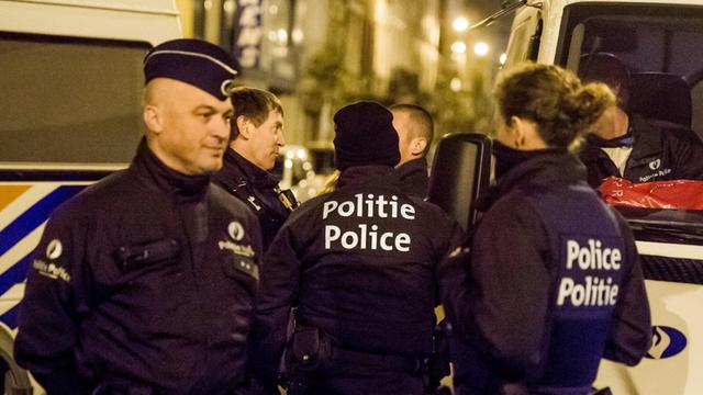 Belgische Polizisten stehen im Brüsseler Stadtteil Anderlecht vor einer Wohnung, nachdem drei Männer festgenommen wurden.