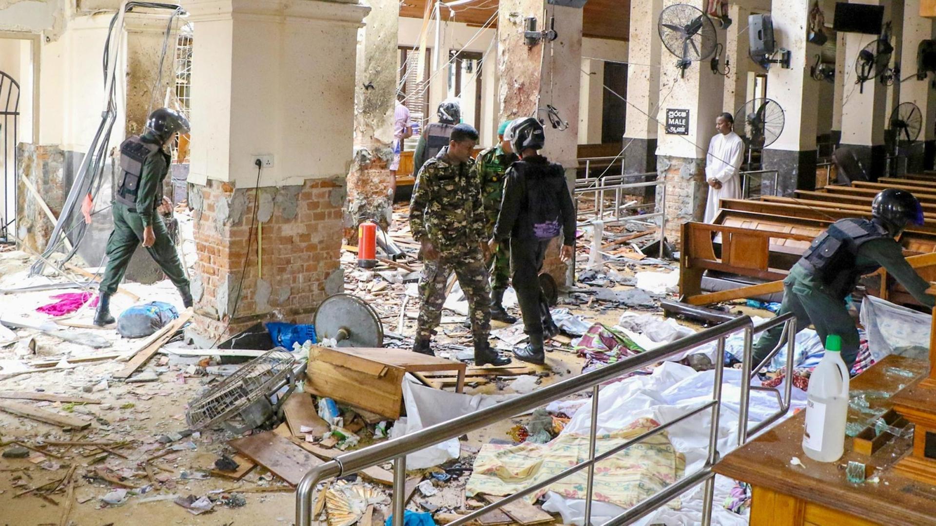 Die St. Antonius Kirche in Colombo ist nach einer Explosion verwüstet, Sicherheitskräfte gehen durch Trümmer Die St. Antonius Kirche in Colombo ist nach einer Explosion verwüstet, Sicherheitskräfte gehen durch Trümmer