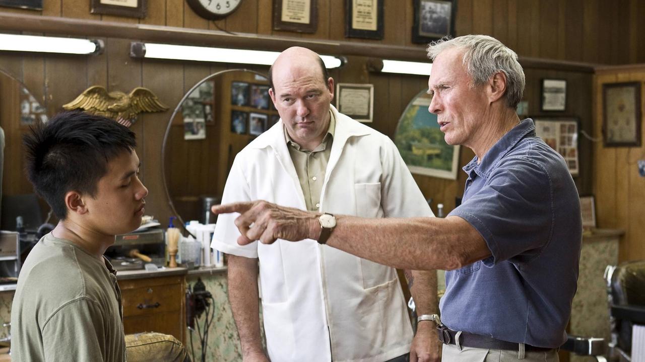 Der alte Clint Eastwood zeigt auf den jungen Bee Vang, John Carroll Lynch steht in der Mitte und schaut zu.