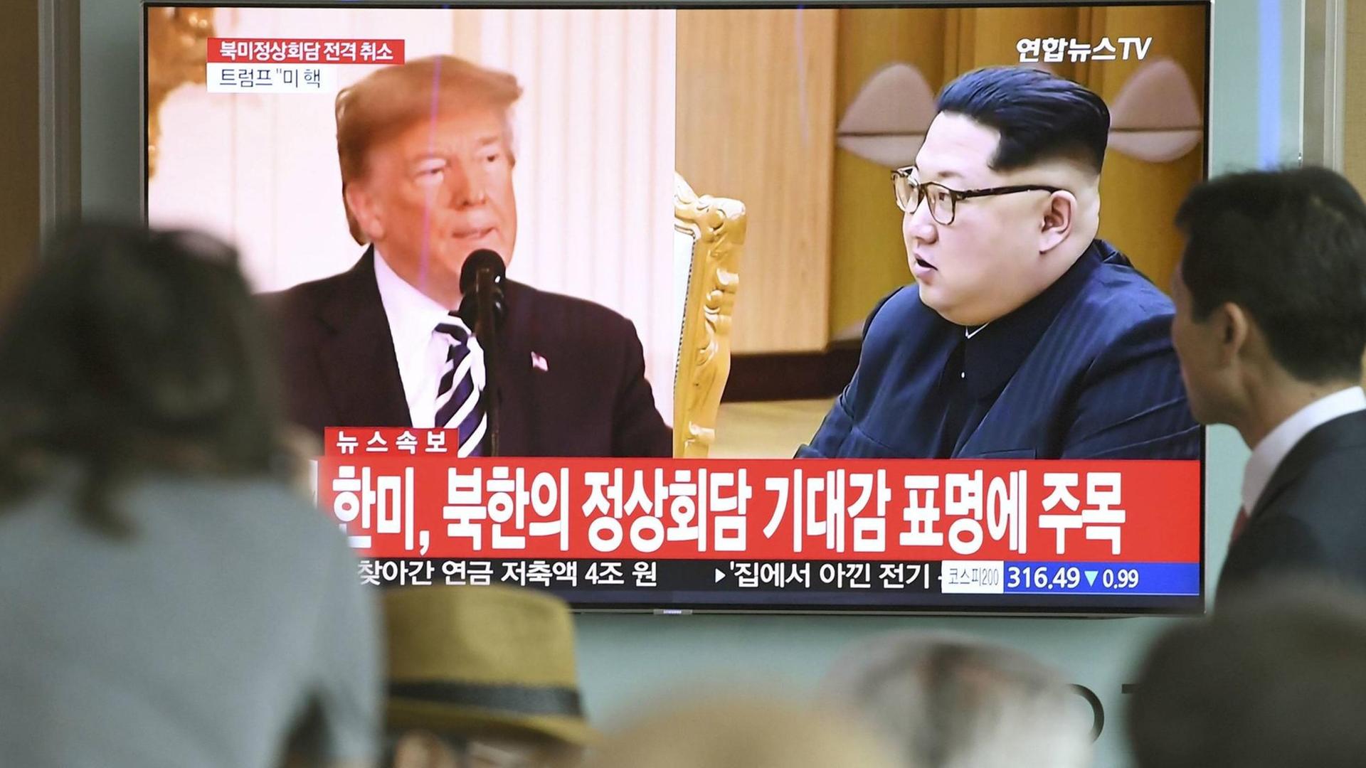 In einer Bahnstation in Seoul verfolgen Menschen einen TV-Beitrag mit Kim und Trump