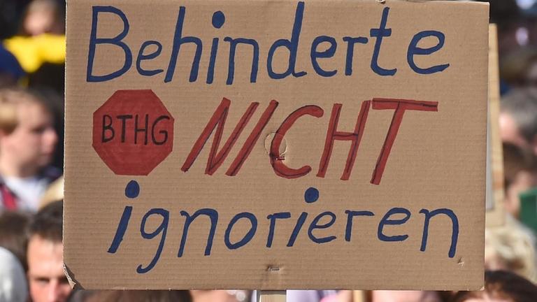 Tausende Menschen mit Behinderung demonstrieren im September 2016 in Hannover. Zu sehen ist ein Plakat mit der Aufschrift "Behinderte nicht ignorieren".