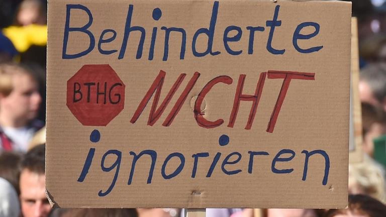 Ein Plakat mit der Aufschrift "Behinderte nicht ignorieren" Ein Plakat mit der Aufschrift "Behinderte nicht ignorieren"