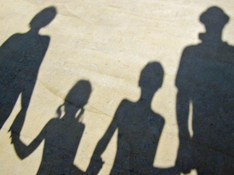 Der Schatten einer Familie, die sich an der Hand hält.