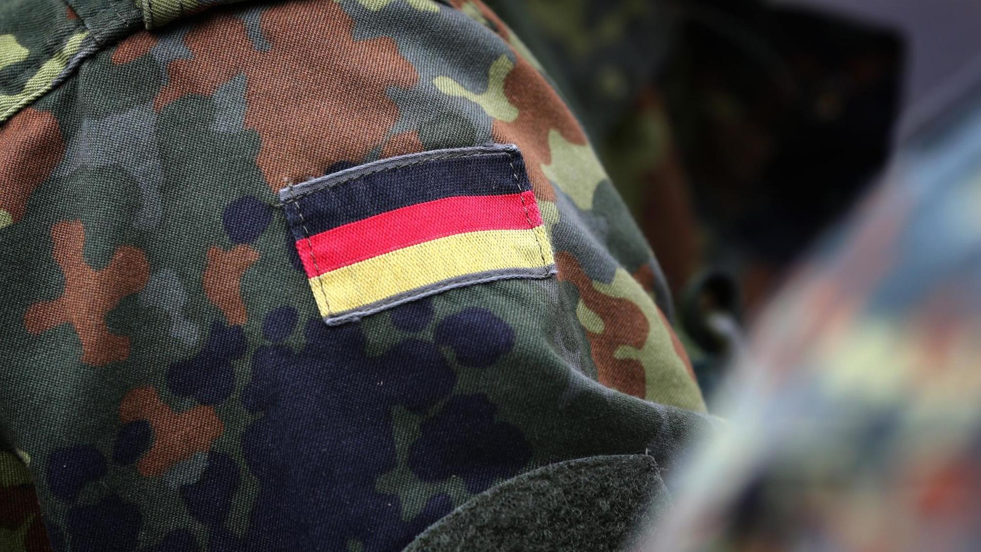 Eine deutsche Fahne an der Uniform eines Soldaten befestigt Eine deutsche Fahne an der Uniform eines Soldaten befestigt