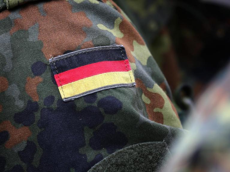 Eine deutsche Fahne an der Uniform eines Soldaten befestigt
