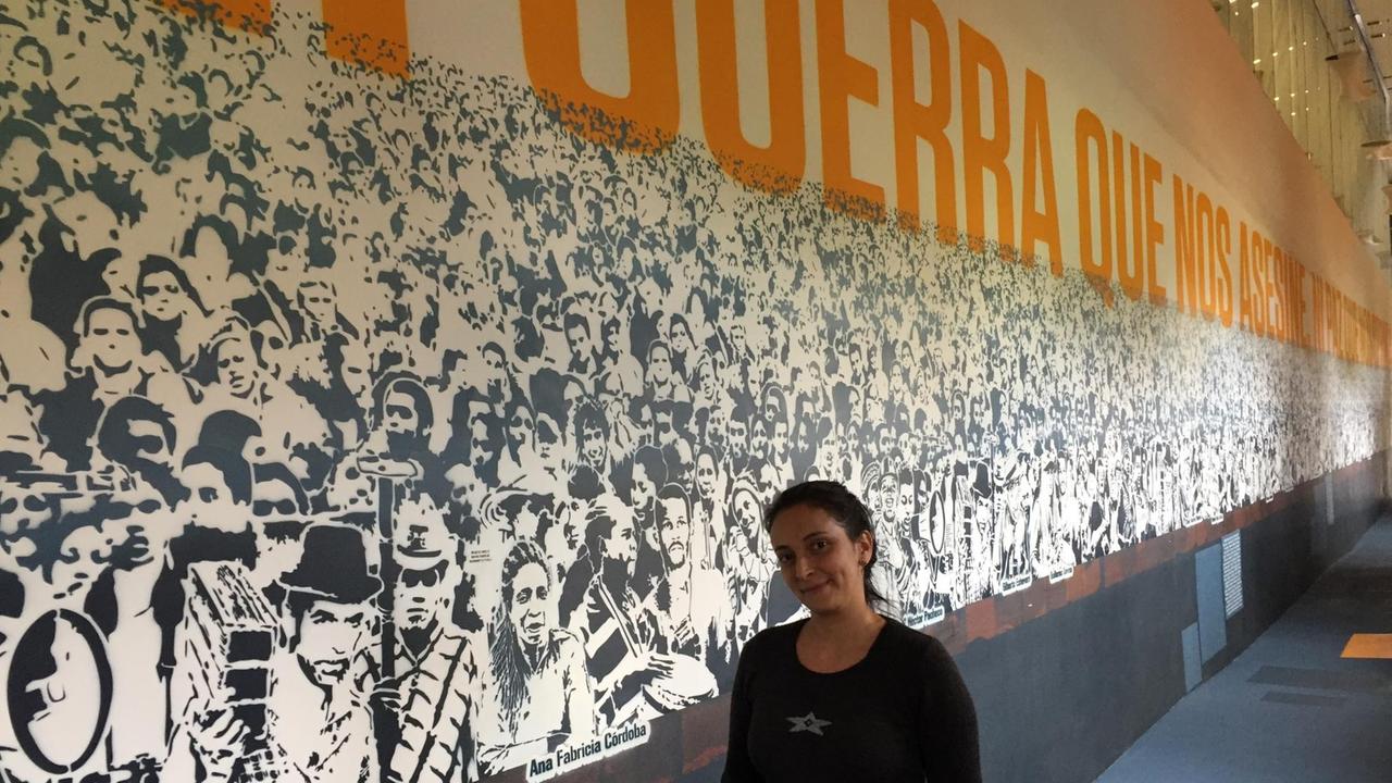 Die Psychologin Cindy Arboleda steht vor einer Fotowand im Museo de la Memoria. Die Psychologin Cindy Arboleda steht vor einer Fotowand im Museo de la Memoria.