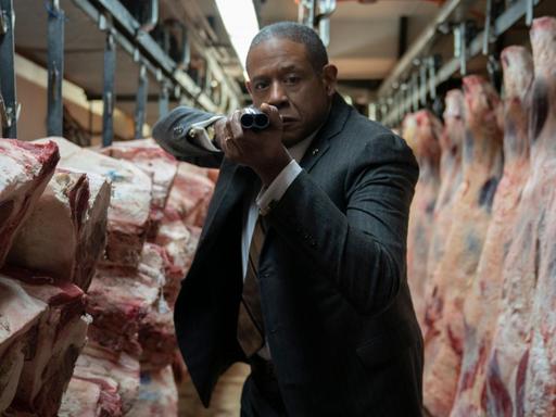 Szene aus der Serie "Godfather of Harlem": Forest Whitaker (als Bumpy Johnson) steht mit angelegter Waffe in einem Schlachthaus.