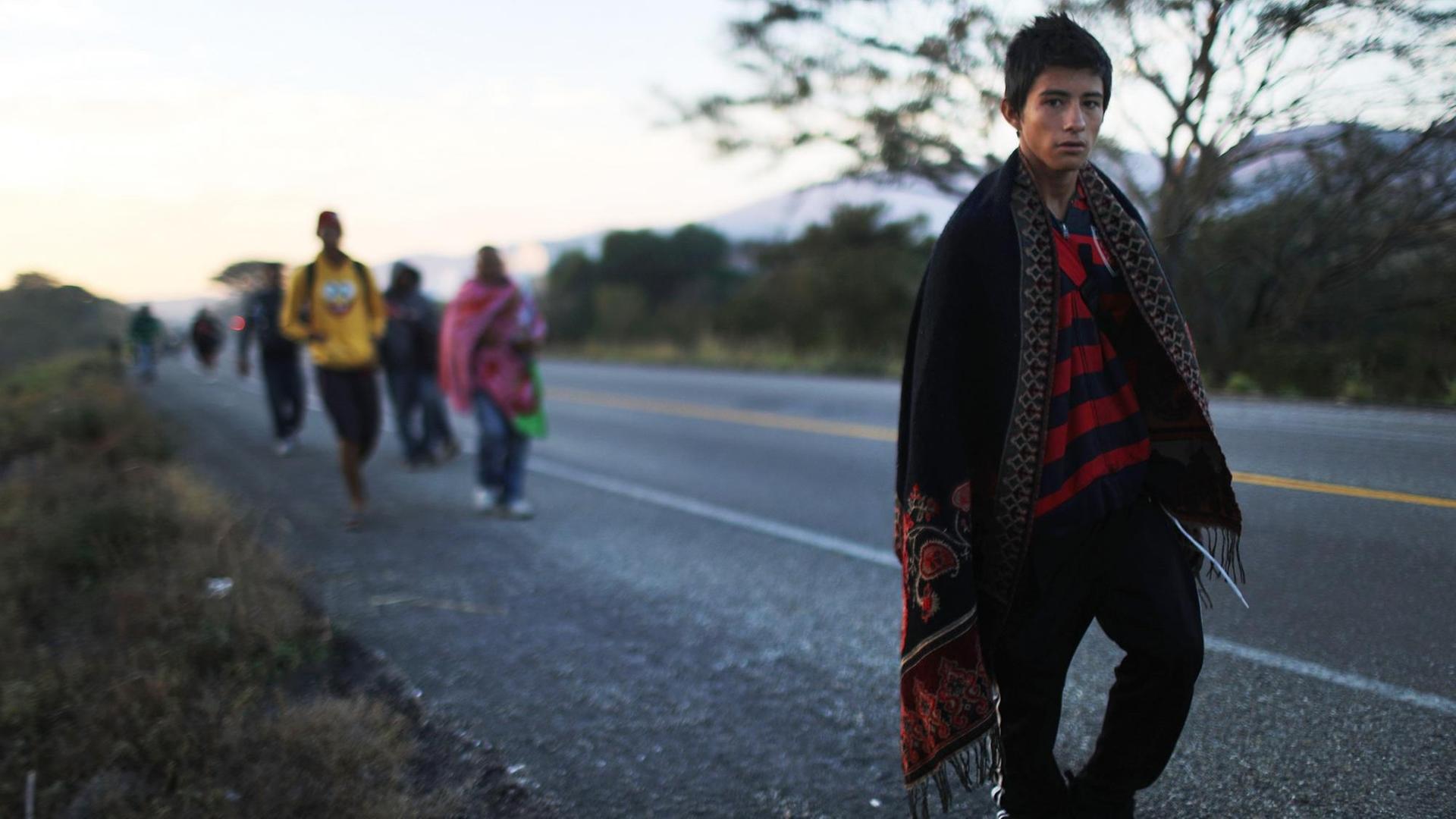 Menschen aus einer Karawane mittelamerikanischer Migranten gehen am 22. Januar 2019 in der Nähe von Santo Domingo Zanatepec, Mexiko, entlang einer Autobahn auf dem Weg in die Vereinigten Staaten. Menschen aus einer Karawane mittelamerikanischer Migranten gehen am 22. Januar 2019 in der Nähe von Santo Domingo Zanatepec, Mexiko, entlang einer Autobahn auf dem Weg in die Vereinigten Staaten.