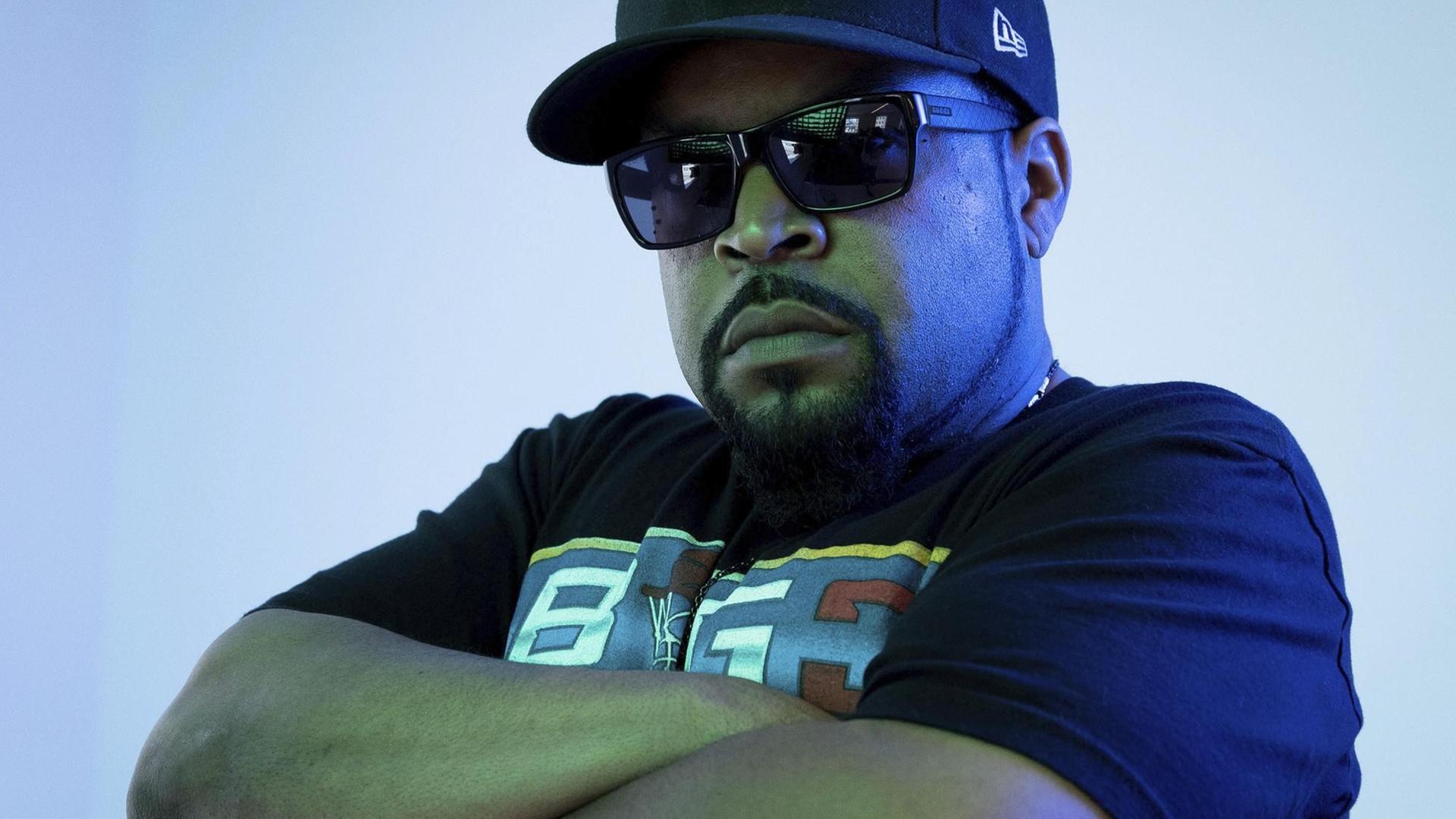 Der Rapper Ice Cube mit Cappy, Sonnenbrille und verschränkten Armen. Der Rapper Ice Cube mit Cappy, Sonnenbrille und verschränkten Armen.