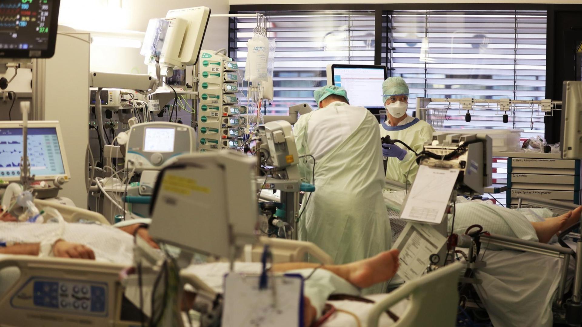 Krankenpfleger behandeln auf einer Intensivstation einen Covid-19 Patienten. Krankenpfleger behandeln auf einer Intensivstation einen Covid-19 Patienten.