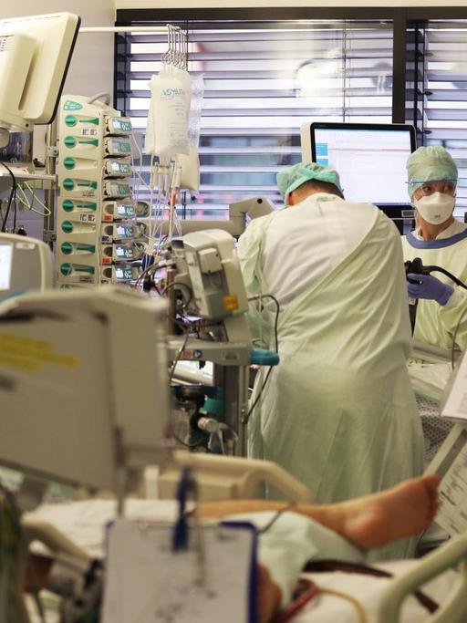Krankenpfleger behandeln auf einer Intensivstation einen Covid-19 Patienten.