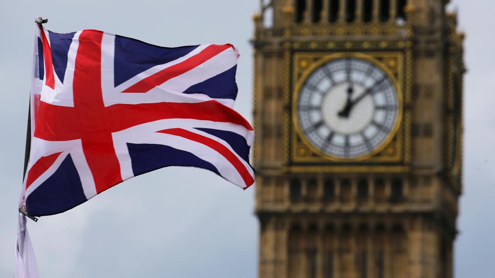 Eine Britische Fahne weht vor dem Uhrenturm Big Ben. Eine Britische Fahne weht vor dem Uhrenturm Big Ben.