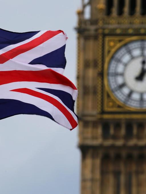 Eine Britische Fahne weht vor dem Uhrenturm Big Ben.