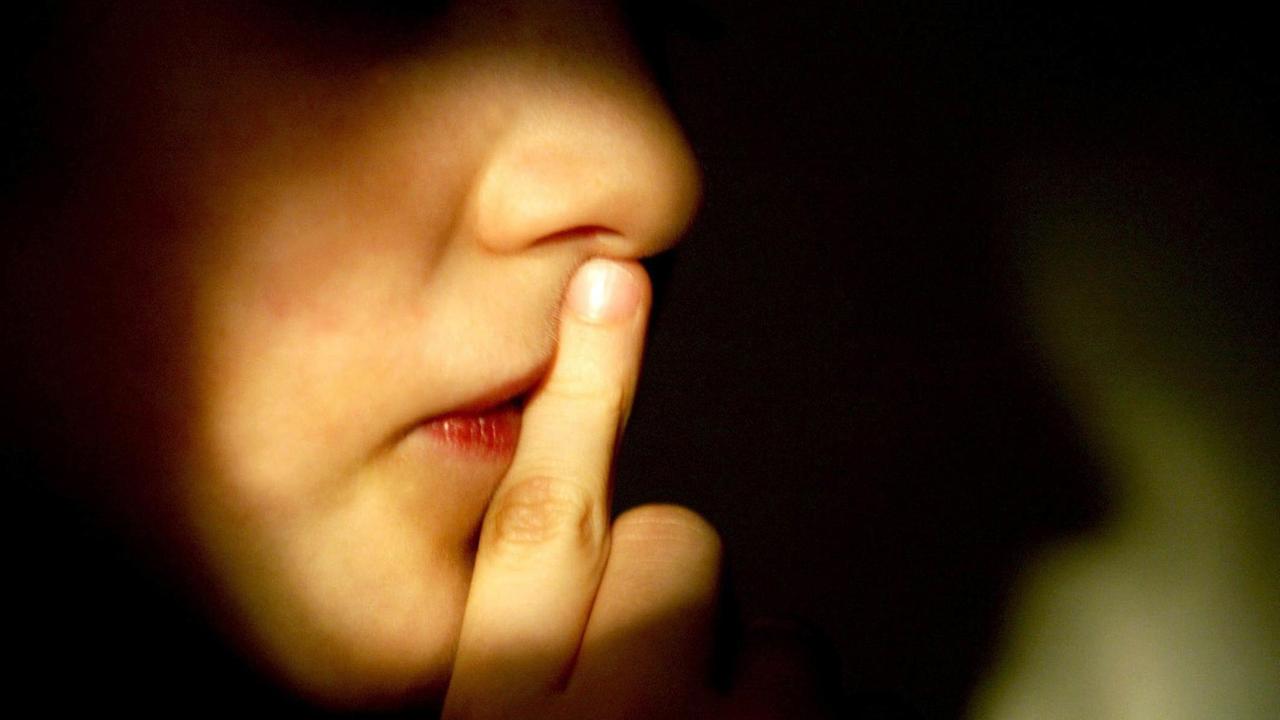 Ein Junge hält den Finger vor den Mund. Ein Junge hält den Finger vor den Mund.