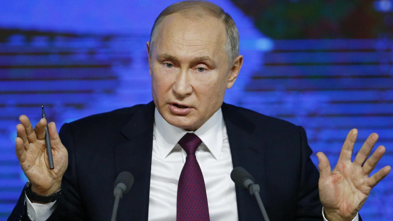 Der russische Präsident Putin steht auf seiner jährlichen Pressekonferenz vor Mikrofonen und hebt beide Hände. Der russische Präsident Putin steht auf seiner jährlichen Pressekonferenz vor Mikrofonen und hebt beide Hände.