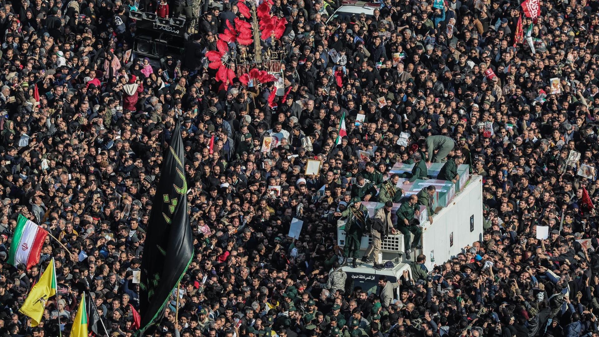 Menschen drängen sich um Särge in Teheran. Menschen drängen sich um Särge in Teheran.