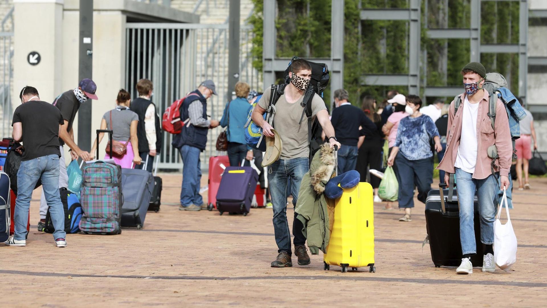 Deutsche Touristen stehen mit Gepäck im Kapstadt-Stadion, bevor sie mit einem Charterflug von Südafrika nach Deutschland reisen. Deutsche Touristen stehen mit Gepäck im Kapstadt-Stadion, bevor sie mit einem Charterflug von Südafrika nach Deutschland reisen.