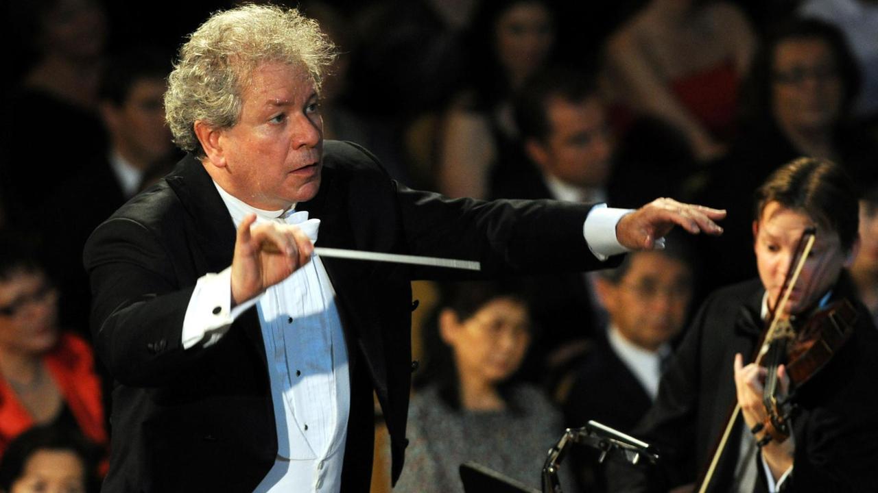 Belohlavek dirigiert mit Elan das Orchester und schwingt den Taktstock. Belohlavek dirigiert mit Elan das Orchester und schwingt den Taktstock.